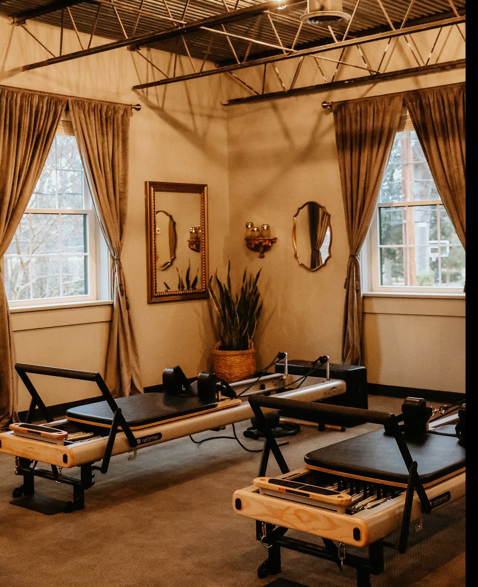 Gold-framed mirrors and reformers in the Belmont Pilates studio at William Henry the Spa.