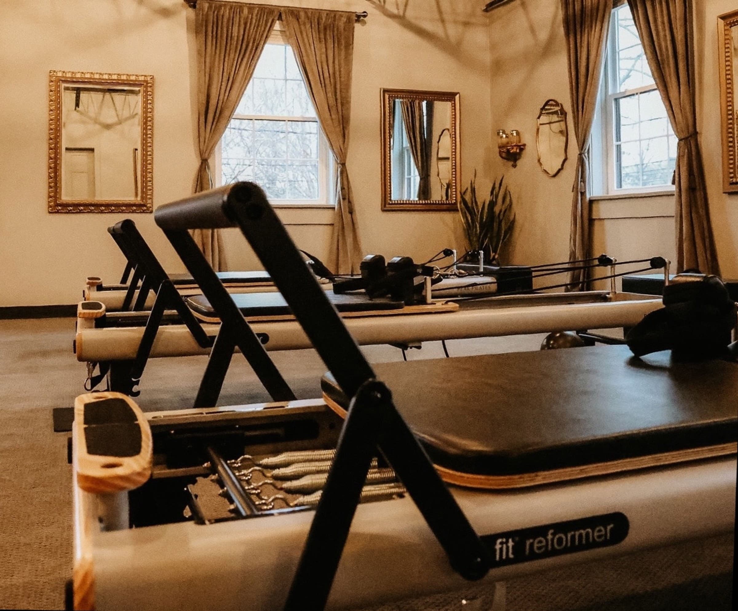 First-timer view of reformers lined up in the Wellness Experience Pilates studio in Belmont, NC.
