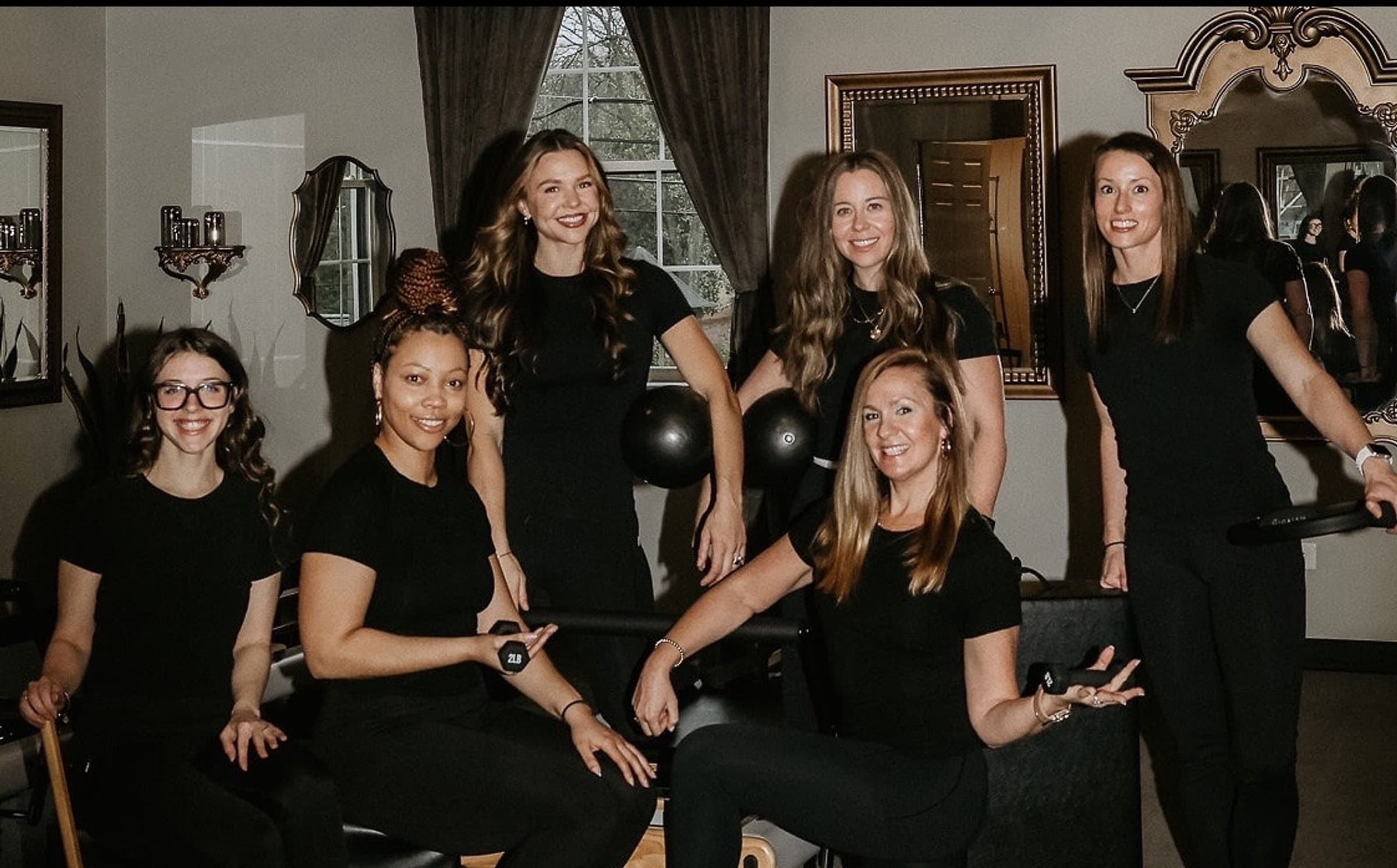 Warm, gold-accented Pilates studio in Belmont prepared for a Sculpt class with reformers and space to stand.